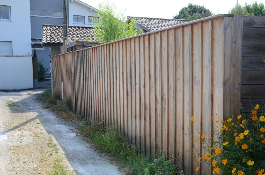 Clôture en bois le long d’une allée