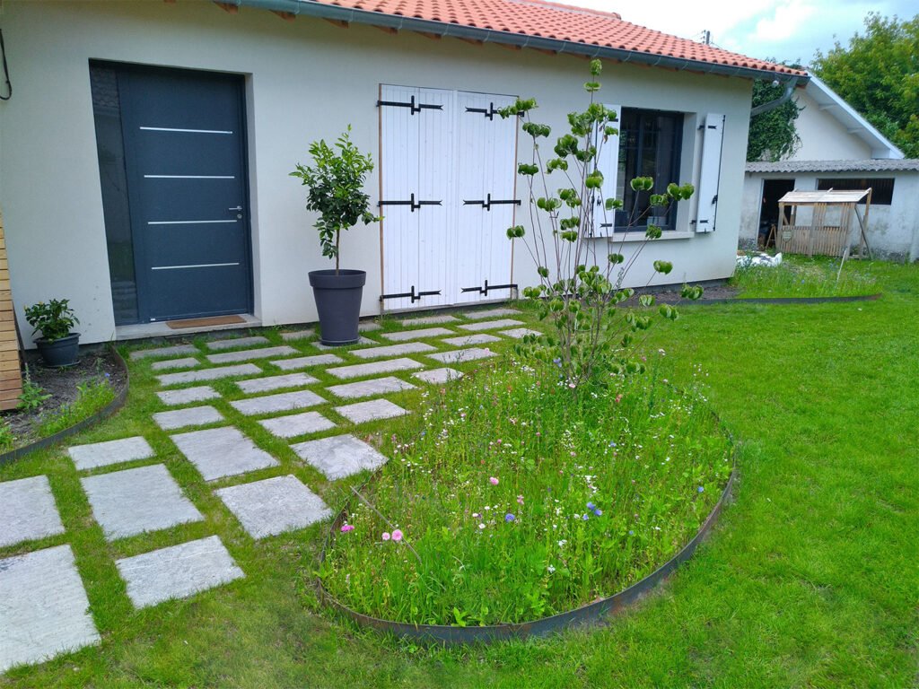 Allée en dalles avec joints gazon devant une maison