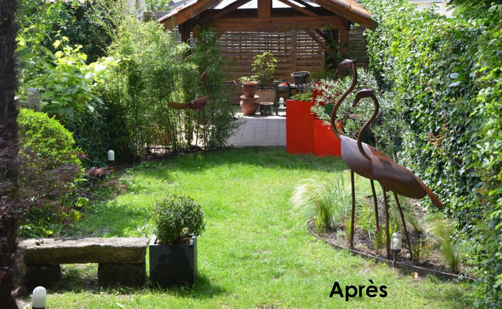 Petit jardin de ville avec sculpture et pelouse